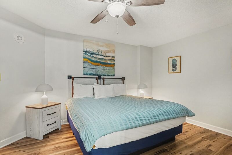 Primary bedroom with king bed and coastal artwork